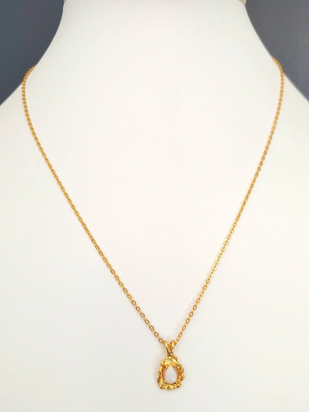 Delicate gold necklace with gold and white opalescent stone pendant